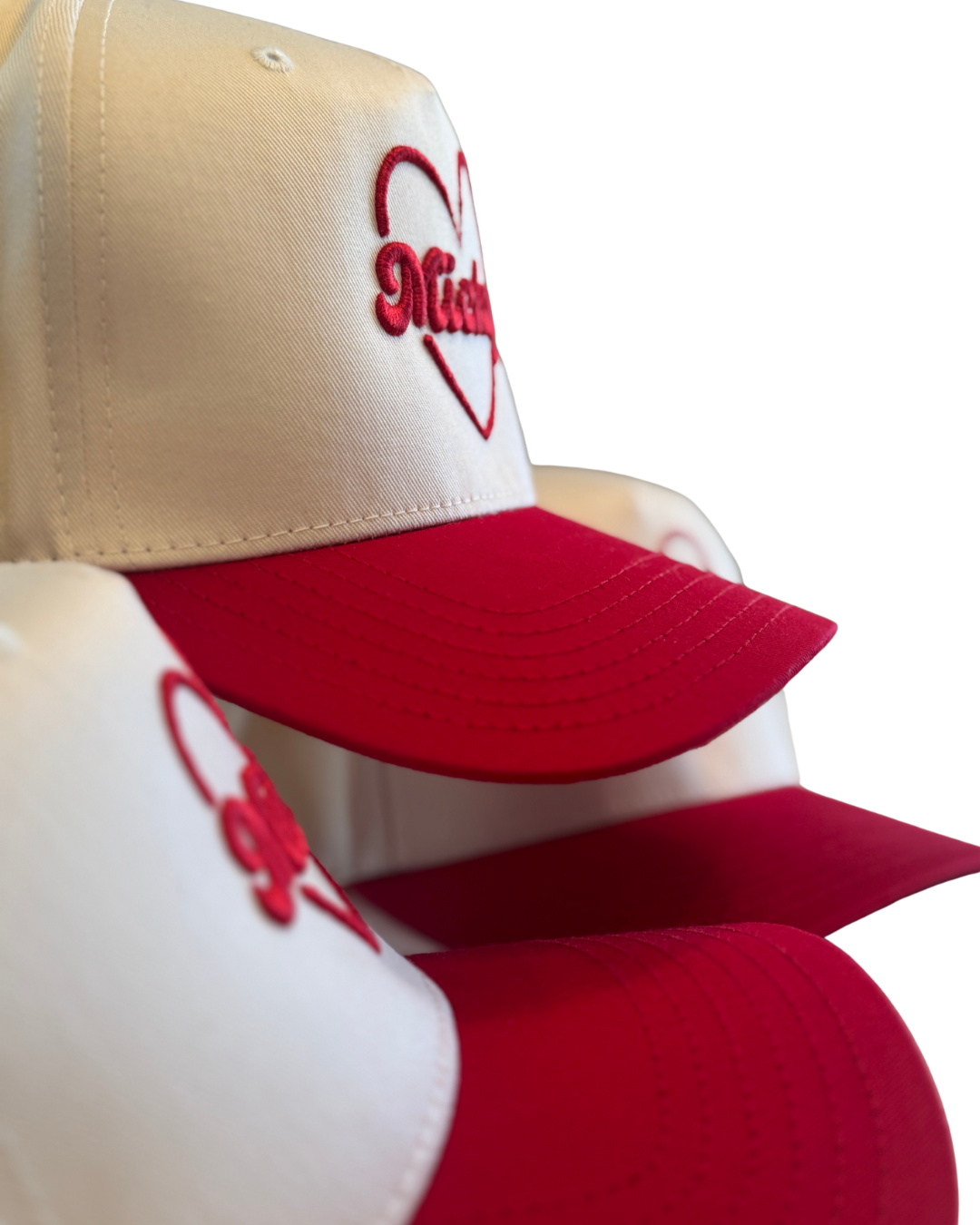 White and red embroidered hats with hearts and character-inspired designs