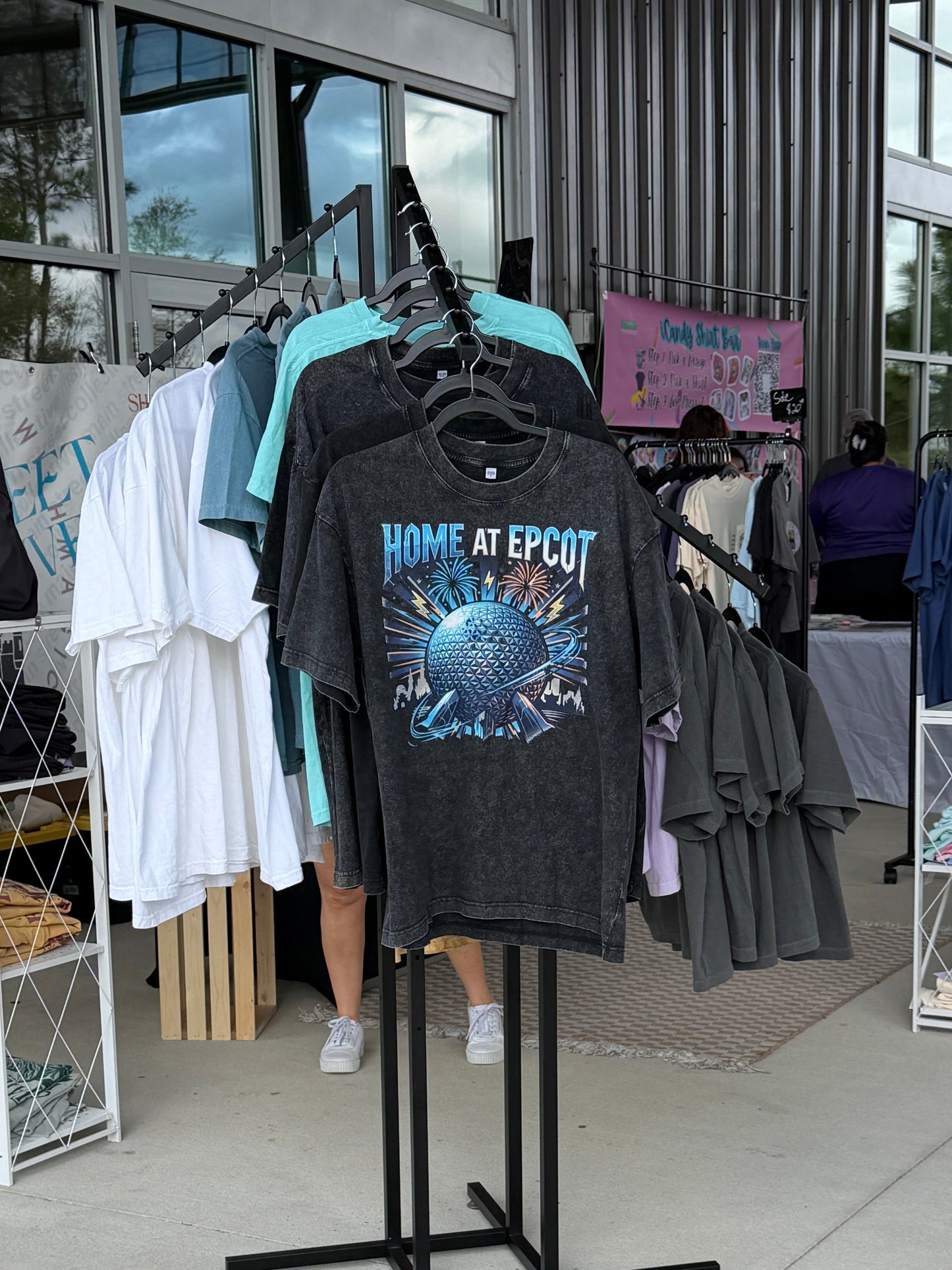 Disney-inspired Home at Epcot T-shirt on display at outdoor apparel market