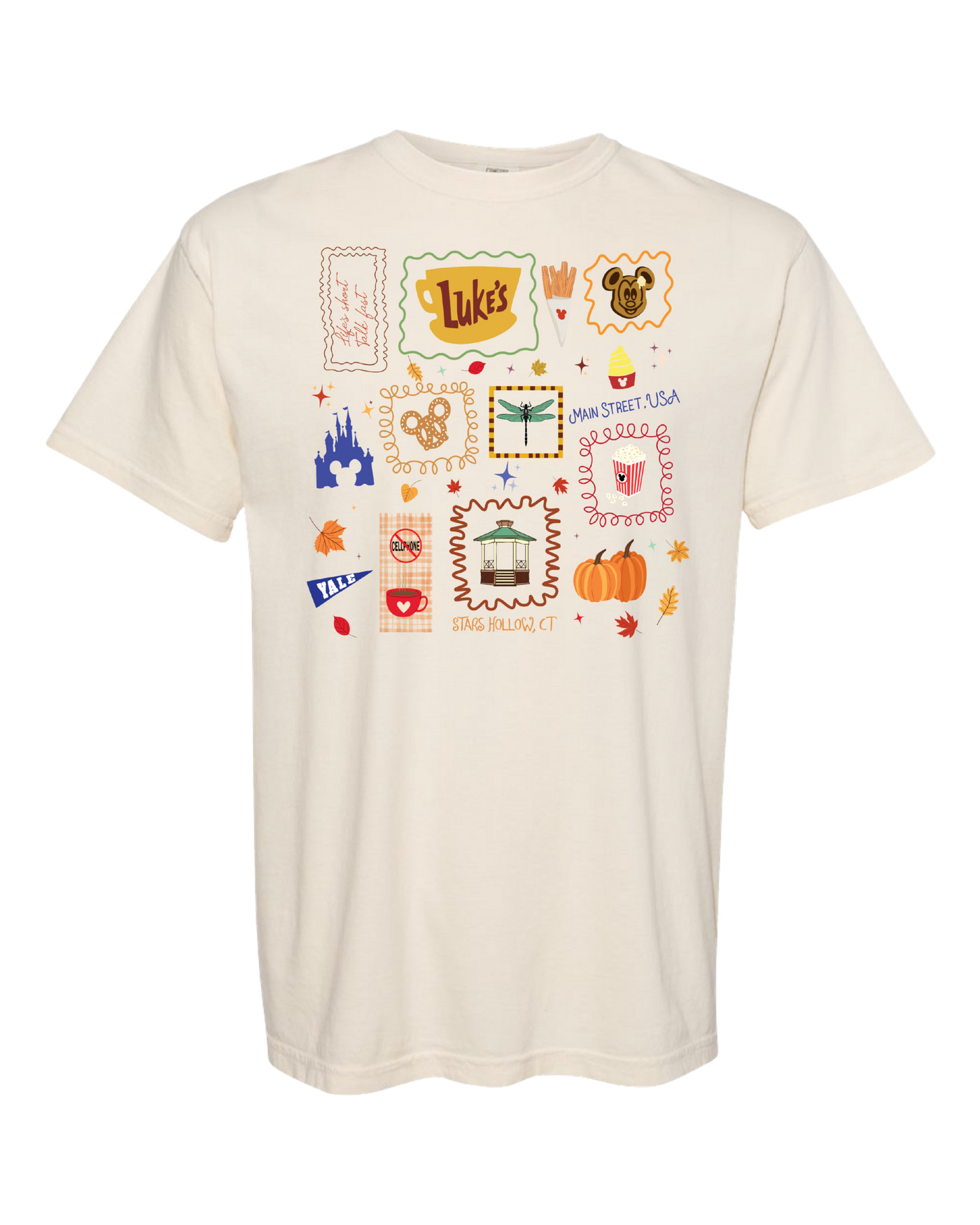 Cream t-shirt with whimsical Disney-inspired icons, castle, Mickey pretzel, and fall leaves.