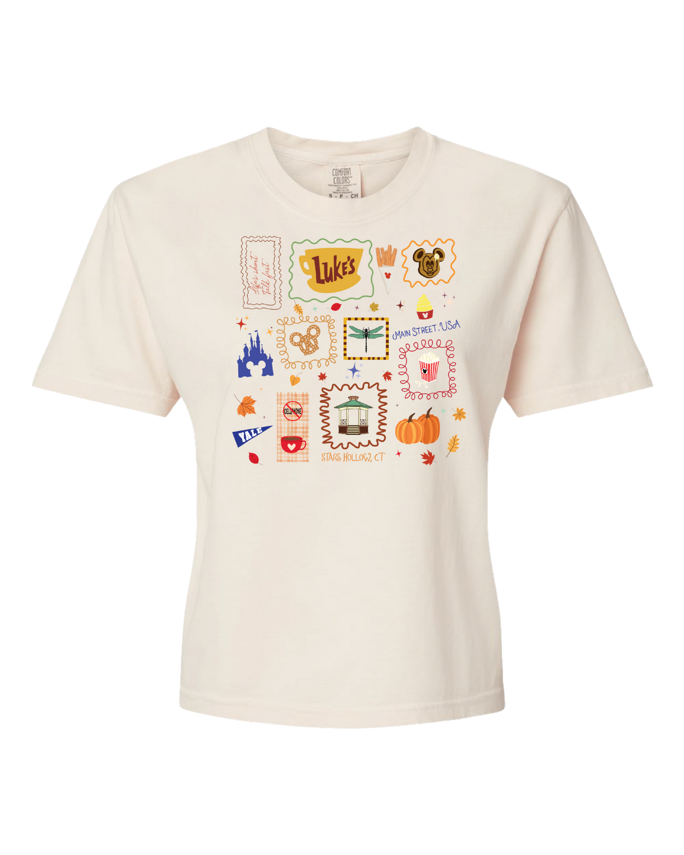 Cream t-shirt with colorful, whimsical icons including Luke's sign, pumpkins, fall leaves, and castle.