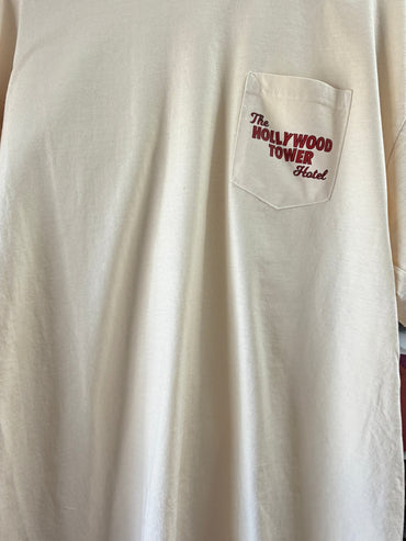 Beige t-shirt with front pocket featuring The Hollywood Tower Hotel text in red.