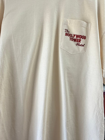 Beige t-shirt with front pocket featuring The Hollywood Tower Hotel text in red.