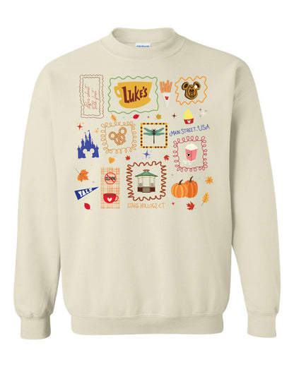 Sand crewneck sweatshirt with colorful fall and Main Street USA themed icons and graphics on front.