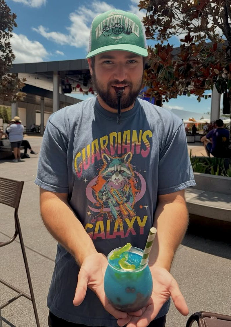 Man outdoors wearing Guardians of the Galaxy retro shirt holding blue themed drink