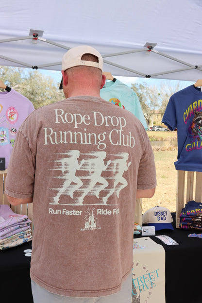Man wearing Rope Drop Running Club Disney-inspired graphic tee at outdoor apparel booth