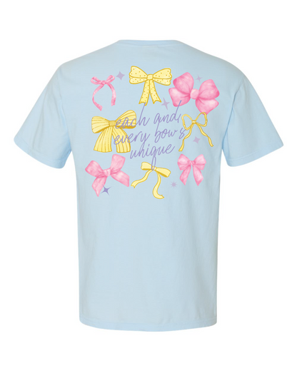 Light blue t-shirt with colorful bows and decorative text on the back, Disney-inspired apparel