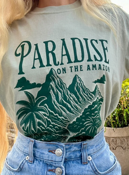 Woman wearing a Paradise on the Amazon graphic t-shirt with mountain and palm tree design