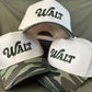 Three caps with 'WALT' branding on a green background