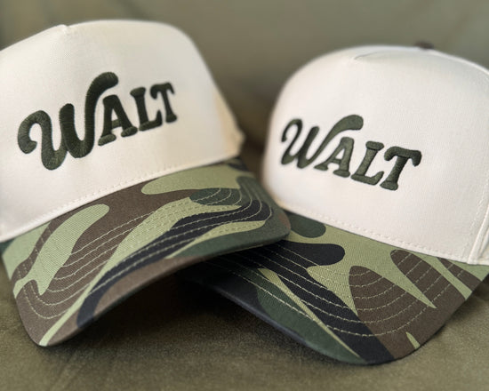 Two hats with 'WALT' branding on a green background